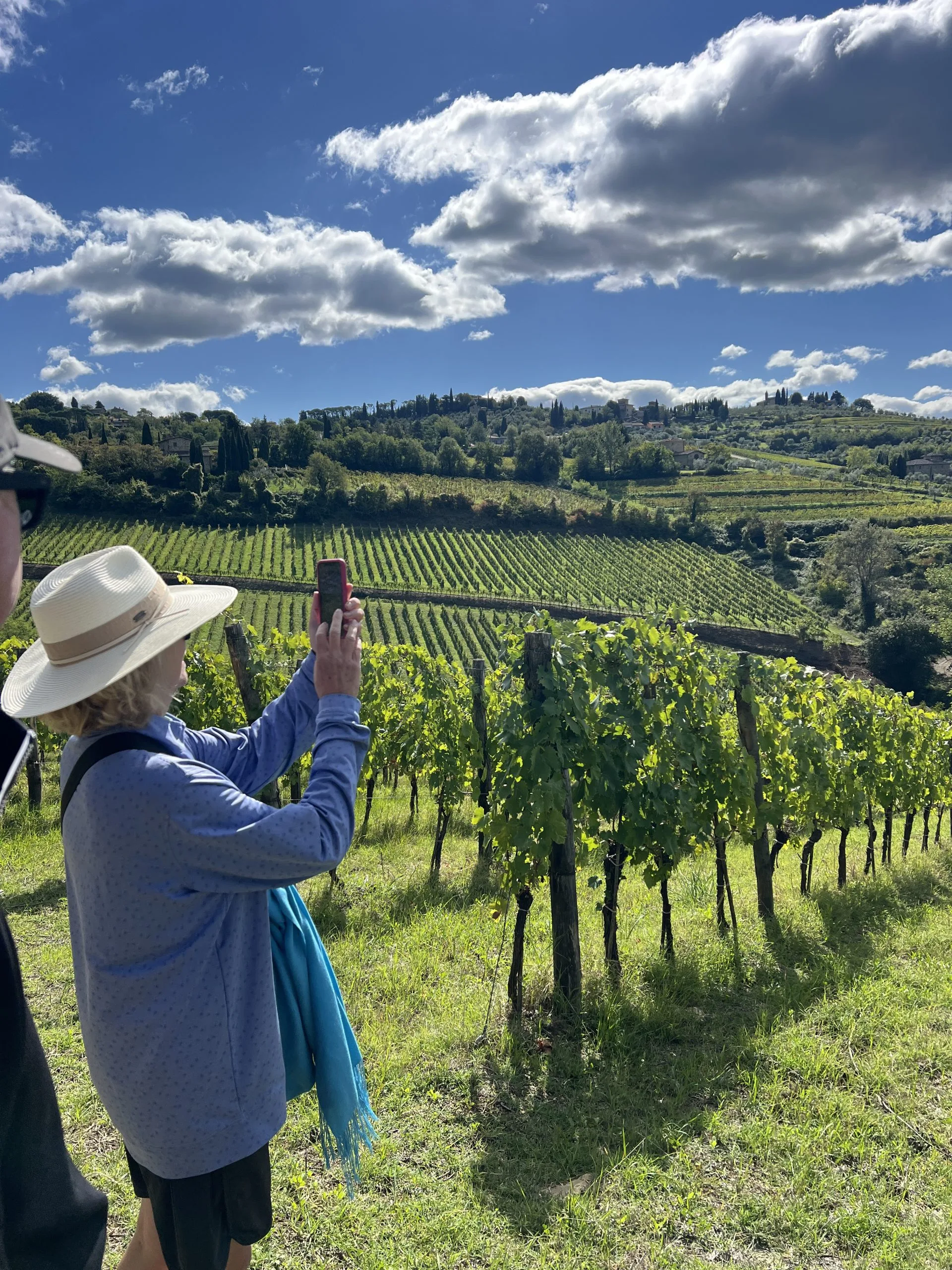Guests walking between vineyards on a full-day Chianti Classico wine hiking tour from Florence