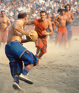Players in medieval costume competing during Calcio Storico Florence in Piazza Santa Croce